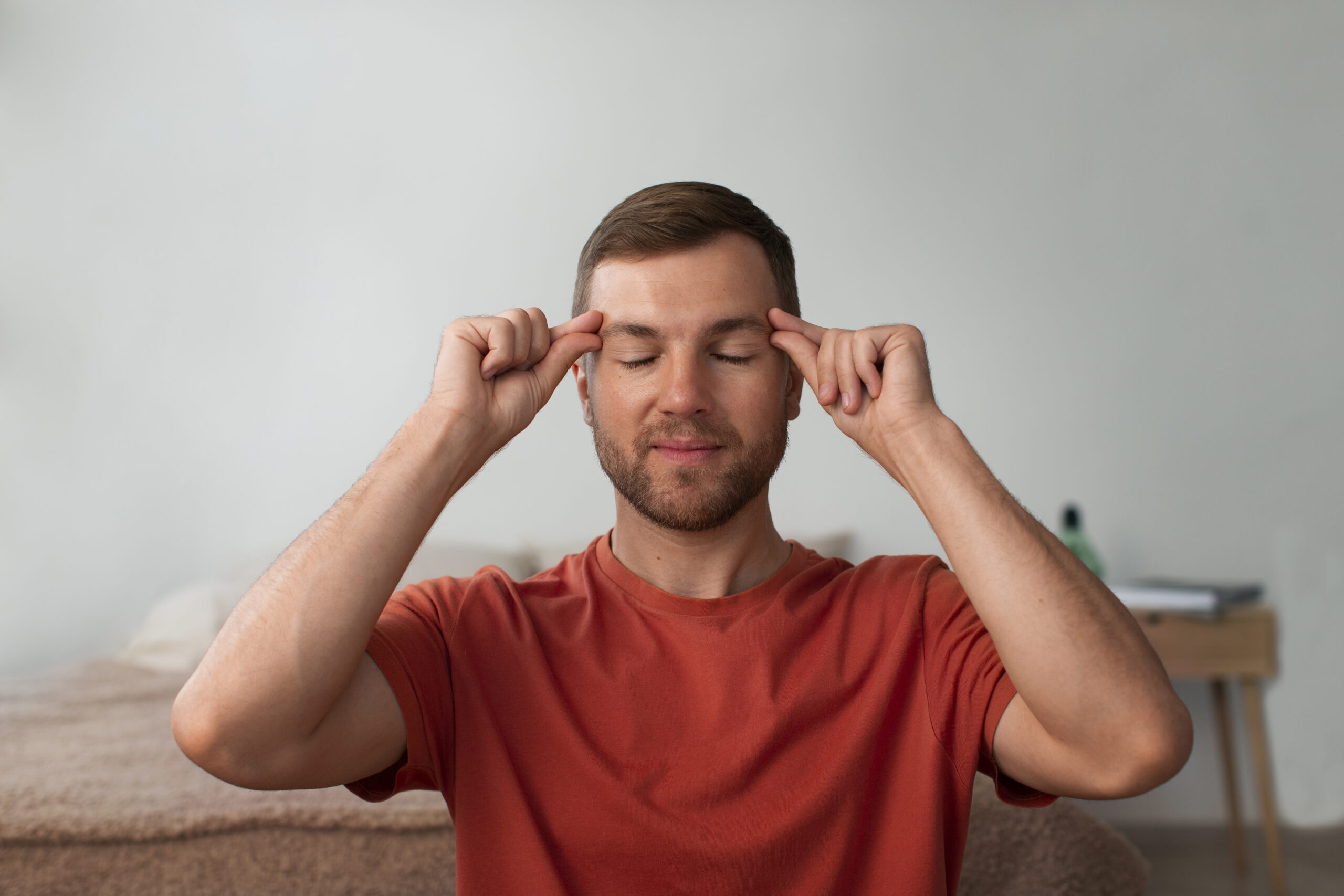 Person gently tapping on forehead, showing EFT tapping practice