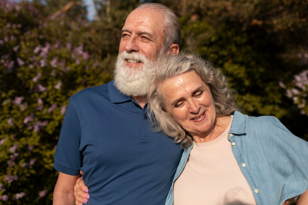 Sexual Satisfaction After 50: Understanding Health Benefits of Old Age Sex Elderly couple smiling while holding hands, symbolizing sexual satisfaction