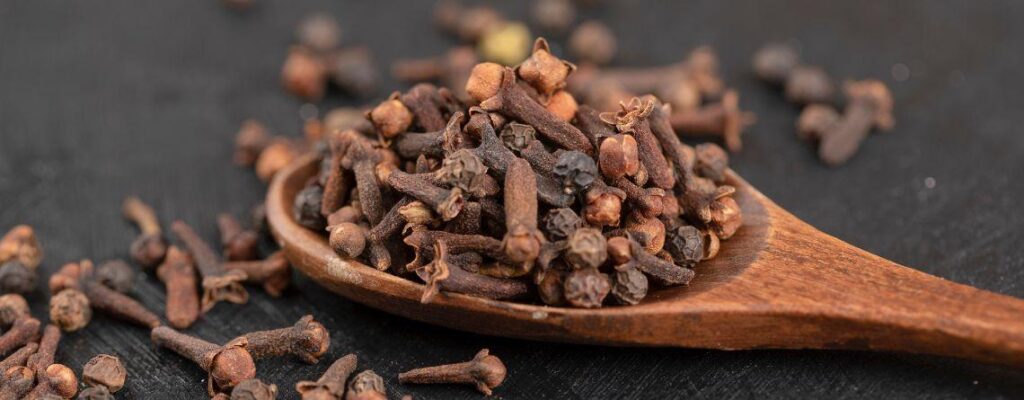 Dried cloves in a wooden bowl showcasing health benefits|8 Unmissable Health Benefits of Cloves or Laung and How to Use It