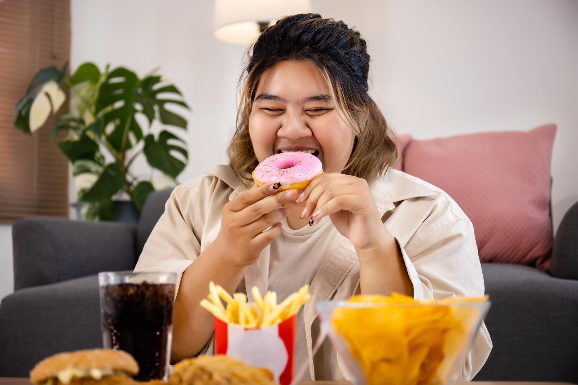 Woman is eating dessert symbolising craving for sweets